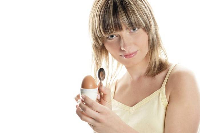 Donna che sta per mangiare un uovo