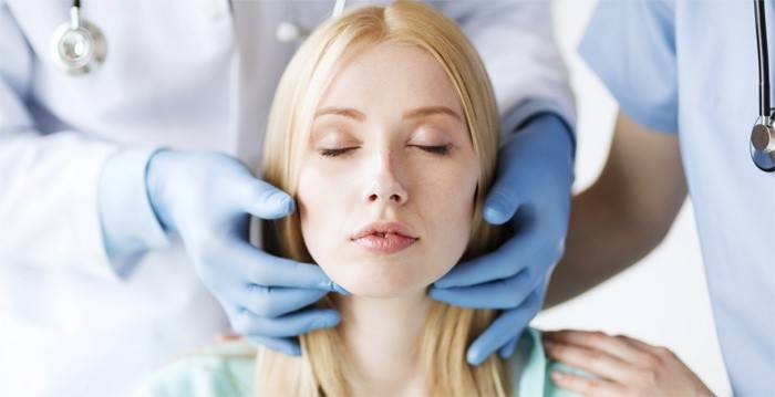 Lægen undersøger patientens hals