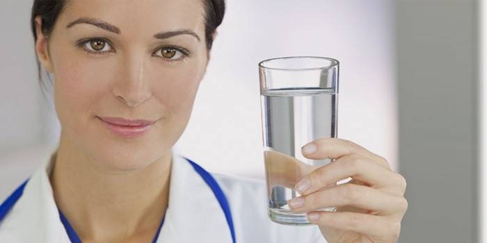 La ragazza tiene un bicchiere d'acqua
