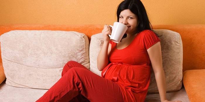 La ragazza incinta beve il cacao