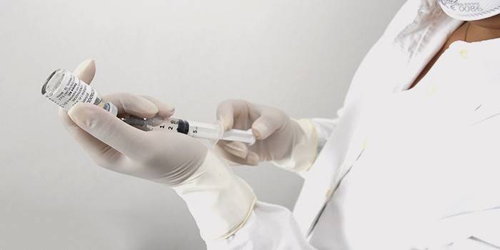 Nurse draws solution into syringe