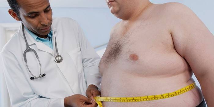 El médico mide el estómago del paciente.