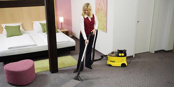 Girl ay vacuuming ang karpet