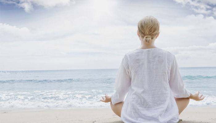 Ein Mädchen liest das tibetische Mantra am Meer
