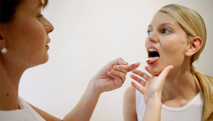 Cổ họng của cô gái được kiểm tra