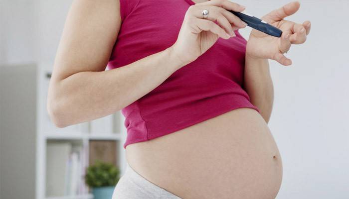 O femeie însărcinată își verifică glucoza din sânge pentru diabet