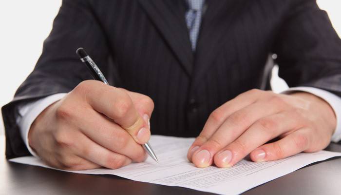 Un hombre escribe una declaración.