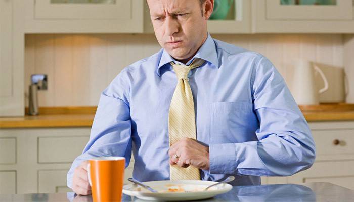 Pesadez en el estómago después de comer en un hombre.