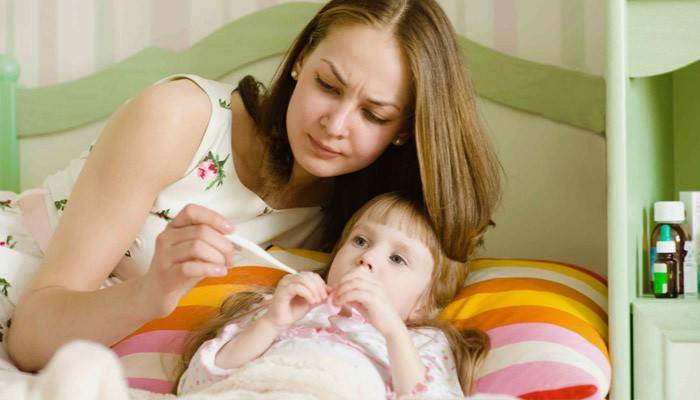 Mẹ đo nhiệt độ của bé.