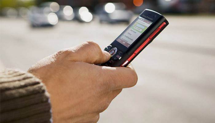 Ένας άνθρωπος καλεί ένα μήνυμα SMS σε ένα κινητό τηλέφωνο