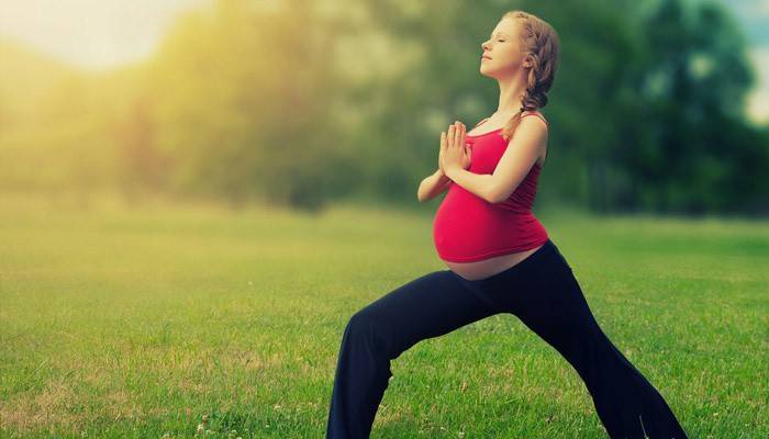 Fata însărcinată face exerciții în aer liber