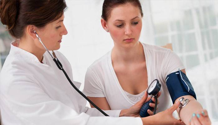 Il medico misura il polso e la pressione di una ragazza con un battito cardiaco accelerato