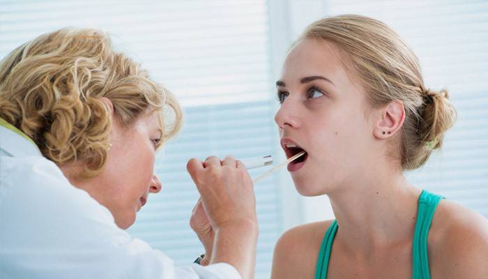 Doktor überprüft die Kehle des Patienten