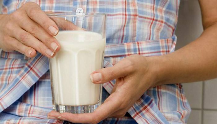 Fata ține un pahar de kefir