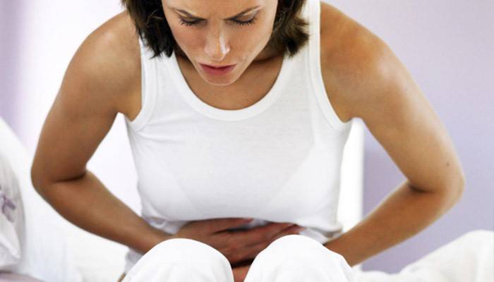 لدى المرأة ألم في المعدة بسبب وجود الطفيليات