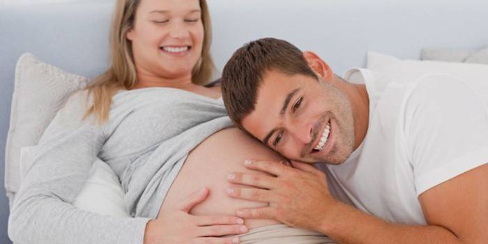 A man listens to a baby moving in his mother’s tummy