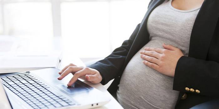 Femeie însărcinată la computer