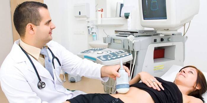 O médico faz a garota um ultra-som da cavidade abdominal