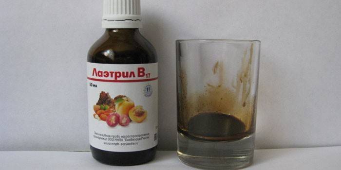Laetrile σε ένα μπουκάλι και ένα ποτήρι