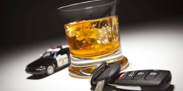 Xe cảnh sát, chìa khóa xe và rượu whisky trong ly