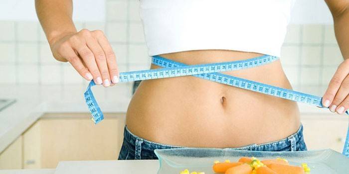 La ragazza misura il volume della vita con un centimetro