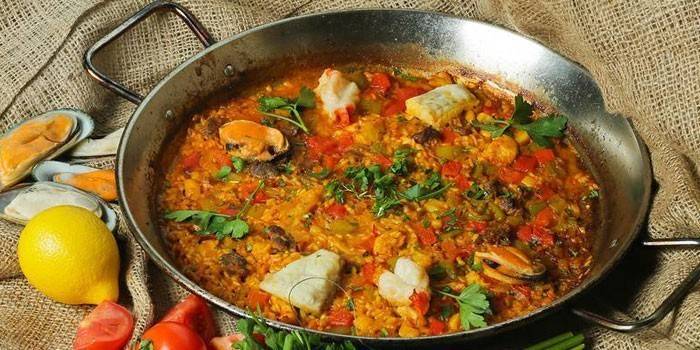 Paella con pesce e funghi in padella