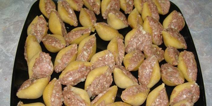 Mit Fleisch gefüllte Muscheln auf einem Backblech vor dem Backen
