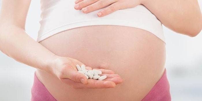 Bà bầu cầm thuốc trên lòng bàn tay