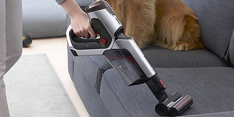ชายคนหนึ่ง vacuums โซฟา