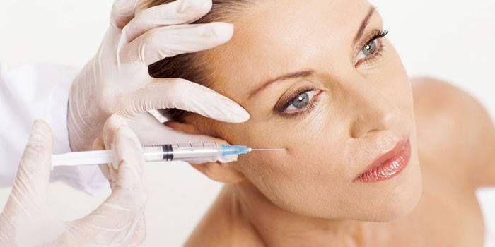 Une femme reçoit une injection sur la joue