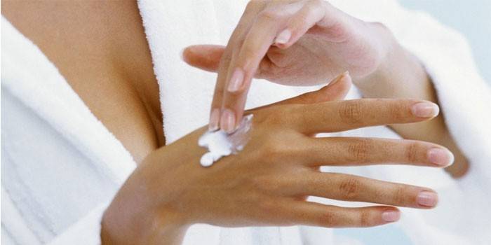 La donna mette la crema sulla sua mano