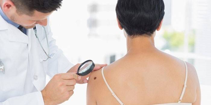 Un dermatologue examine un patient
