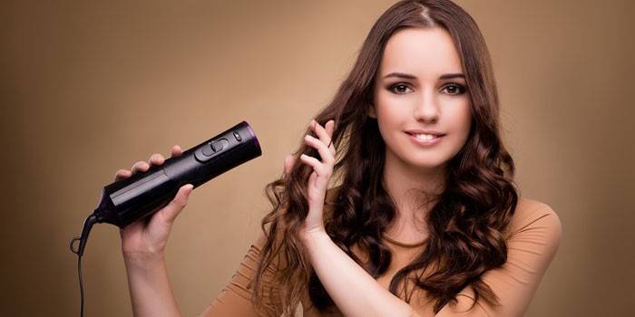 La donna asciuga i capelli con un asciugacapelli