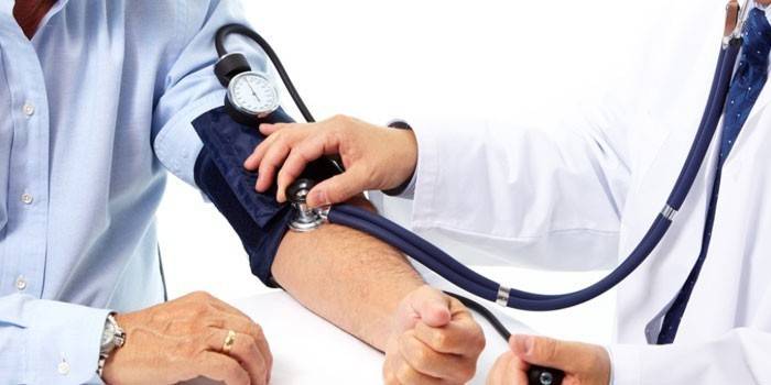 Medicul măsoară tensiunea arterială la un bărbat