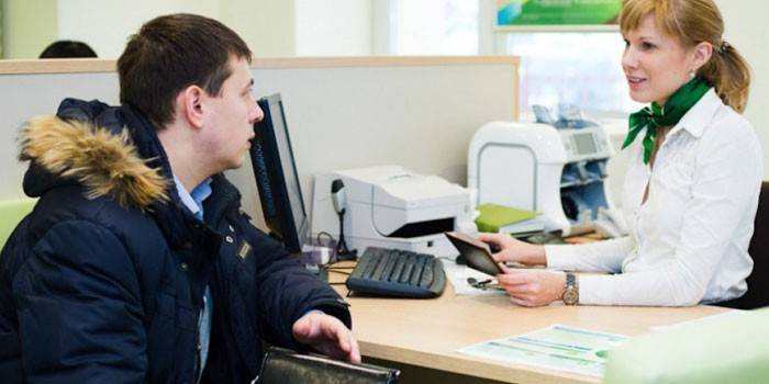 En mann som snakker med en ansatt i Sberbank