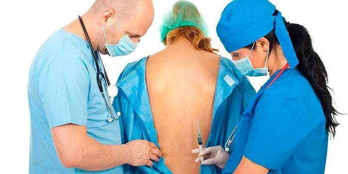 Doktorlar hastaya spinal anestezi yapmaya hazırlanıyorlar