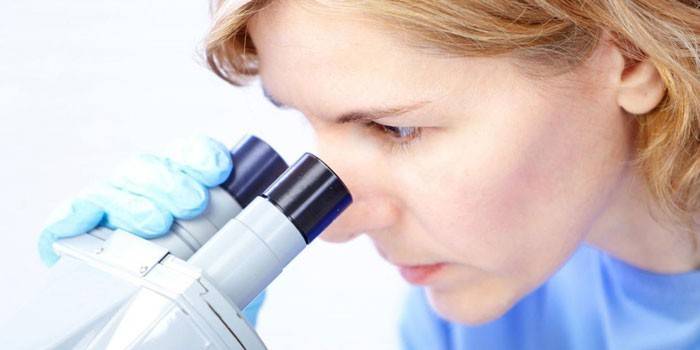Fată care se uită la microscop