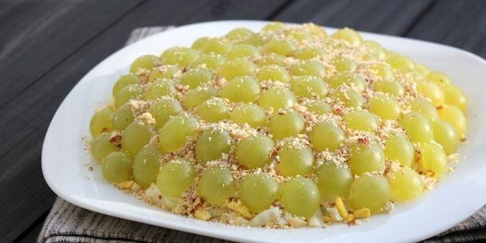 Insalata decorata con uva bianca e pinoli
