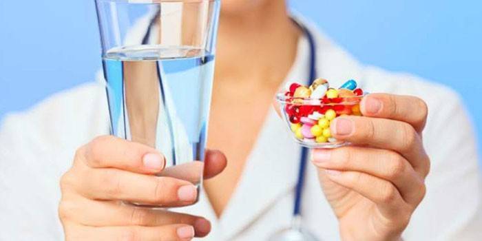 Thuốc với thuốc và một ly nước trong tay