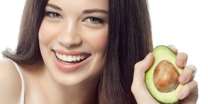 Mädchen hält Avocado in der Hand