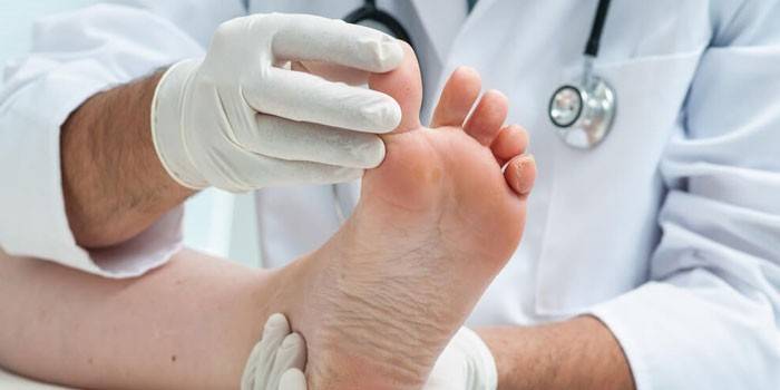 Le médecin examine la jambe du patient