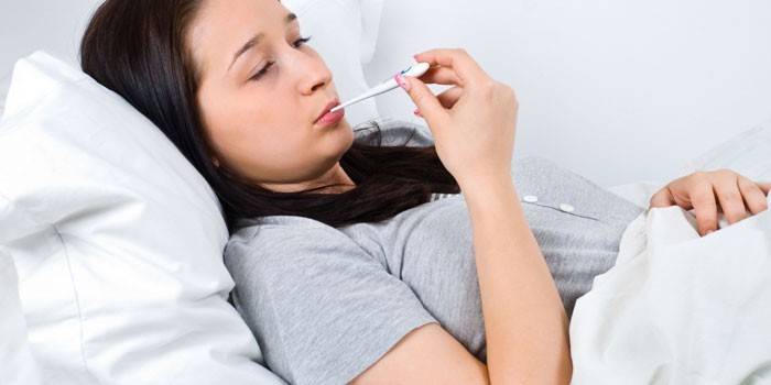 Mädchen mit einem Thermometer im Mund