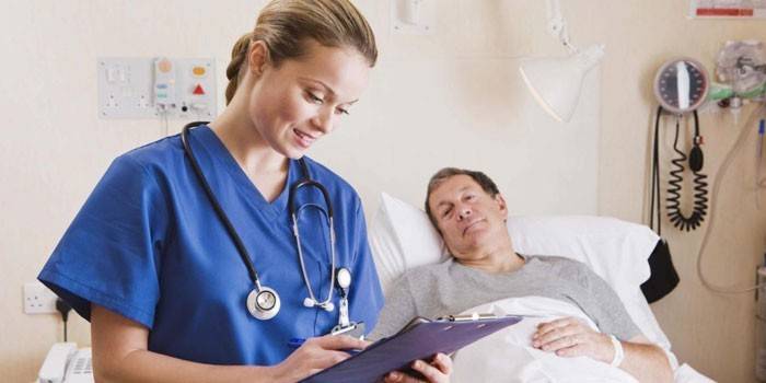 Ein Mann in einem Krankenhausbett und ein Sanitäter