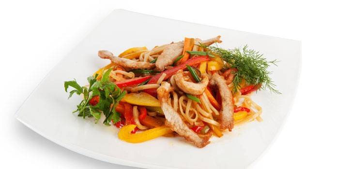 Udon mit Gemüse und Stücken Schweinefleisch auf einer Platte
