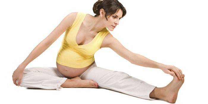 Έγκυος κορίτσι κάνει ασκήσεις stretching