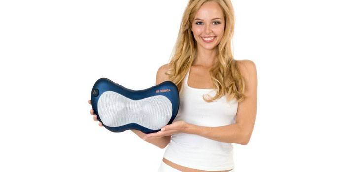 La fille avec un oreiller de massage US-Medica Apple SMP-70 dans ses mains