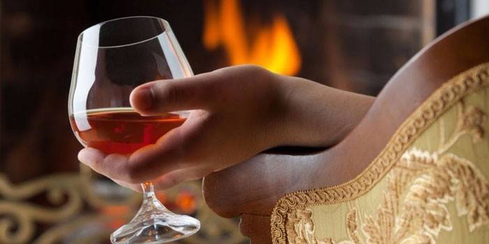 Un pahar de alcool în mâna unei persoane