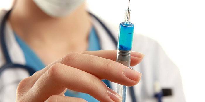 Una jeringa con un medicamento en la mano del médico.