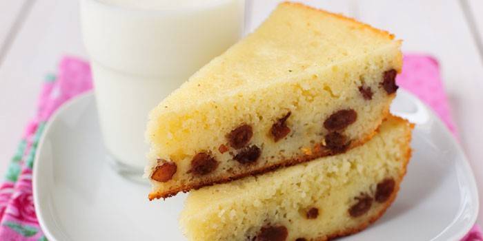 Một miếng bánh semolina với nho khô trên đĩa và một ly sữa