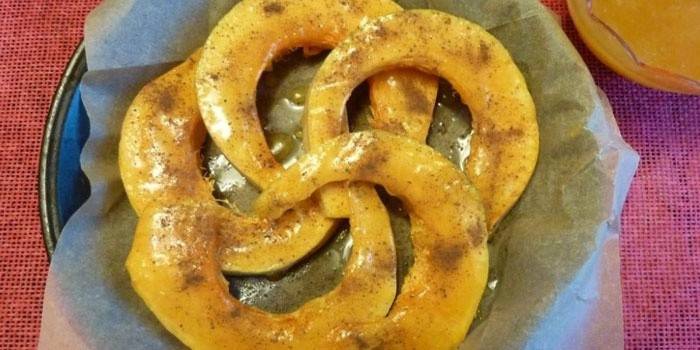 Felie de dovleac presărată cu scorțișoară înainte de a coace la cuptor